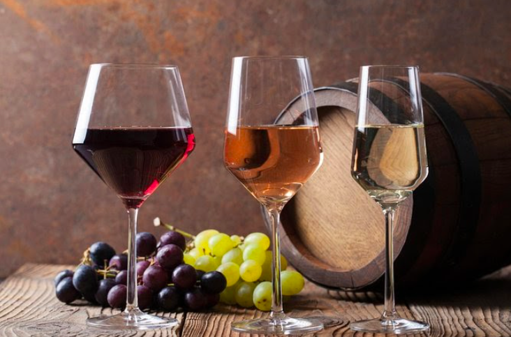 a glass of wine sitting on top of a wooden table