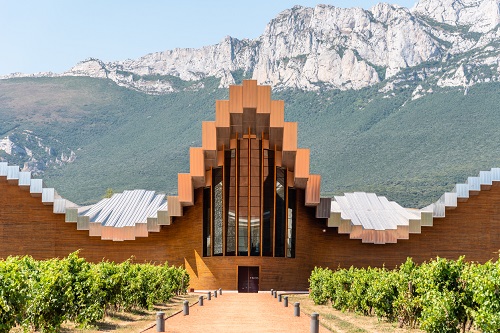 a large building with a mountain in the background